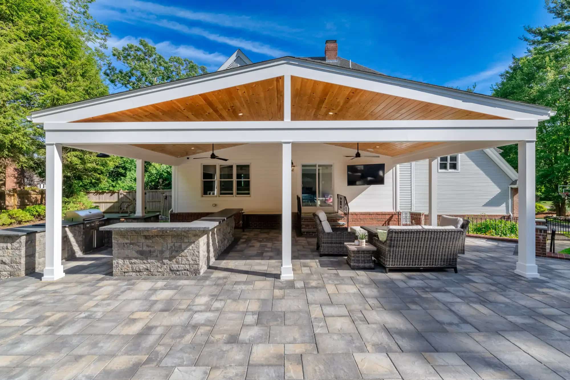 Pavilion with a wood ceiling over an outdoor kitchen, bar, and lounge on a paver patio in North Easton, MA
